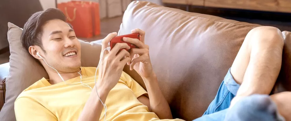 mano-masculina-asiatica-joven-jugando-juegos-telefonos-inteligentes-linea-casual-ocio-saliendo-tumbado-sofa-fin-semana-casa-concepto-ideas-actividad-cuarentena_609648-223